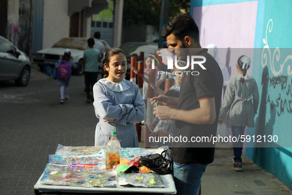 Palestinian students buy from a street vendor outside a United-Nations run school as a new school year begins as Palestinians ease the coron...