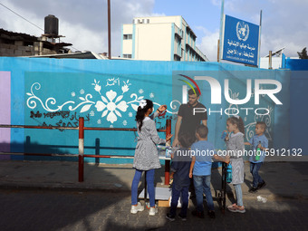 Palestinian students buy from a street vendor outside a United-Nations run school as a new school year begins as Palestinians ease the coron...