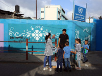 Palestinian students buy from a street vendor outside a United-Nations run school as a new school year begins as Palestinians ease the coron...