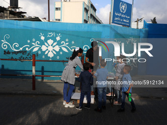 Palestinian students buy from a street vendor outside a United-Nations run school as a new school year begins as Palestinians ease the coron...