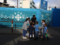 Palestinian students buy from a street vendor outside a United-Nations run school as a new school year begins as Palestinians ease the coron...