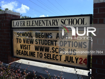 A sign at the entrance to Layer Elementary School advises that the school year will begin on August 17 with several student learning options...