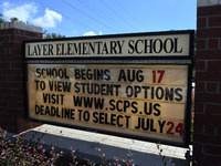 A sign at the entrance to Layer Elementary School advises that the school year will begin on August 17 with several student learning options...