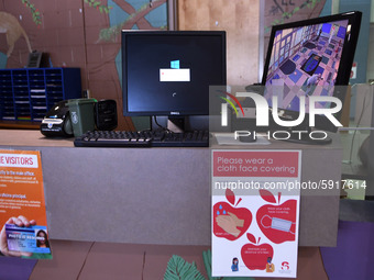 Heath safety precautions are seen posted at the reception desk at Layer Elementary School a week before classes begin for the school year du...