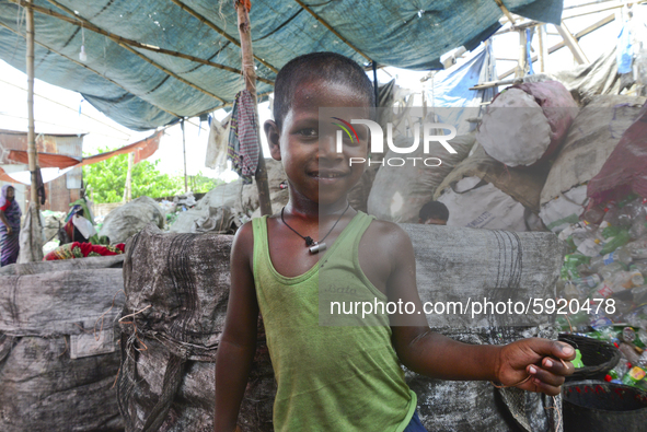 A child of worker’s passing idle time in a recycling factory in Dhaka, Bangladesh, August 12, 2020. Recycling plastic bottles has become a g...