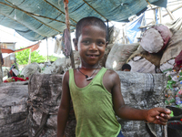 A child of worker’s passing idle time in a recycling factory in Dhaka, Bangladesh, August 12, 2020. Recycling plastic bottles has become a g...