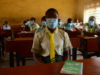 The final year students of Babs Fafunwa Millennium Senior Grammar School, Ojodu, Lagos, Nigeria sit with facemasks in a classroom as they wa...