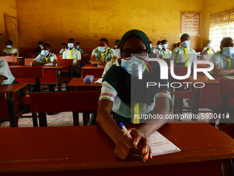 The final year students of Babs Fafunwa Millennium Senior Grammar School, Ojodu, Lagos, Nigeria sit with facemasks in a classroom as they wa...