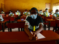 The final year students of Babs Fafunwa Millennium Senior Grammar School, Ojodu, Lagos, Nigeria sit with facemasks in a classroom as they wa...