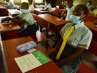 The final year students of Babs Fafunwa Millennium Senior Grammar School, Ojodu, Lagos, Nigeria sit with facemasks in a classroom as they wa...