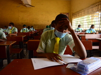 The final year students of Babs Fafunwa Millennium Senior Grammar School, Ojodu, Lagos, Nigeria sit with facemasks in a classroom as they co...