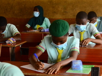 The final year students of Babs Fafunwa Millennium Senior Grammar School, Ojodu, Lagos, Nigeria sit with facemasks in a classroom as they co...