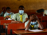 The final year students of Babs Fafunwa Millennium Senior Grammar School, Ojodu, Lagos, Nigeria sit with facemasks in a classroom as they co...