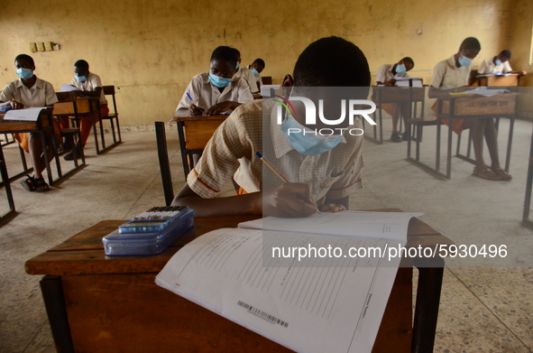 The final year students of Agidinbi Senior Grammar School,Ikeja, Lagos, wearing a facemask write on examination answer sheet during The West...