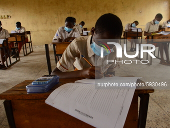 The final year students of Agidinbi Senior Grammar School,Ikeja, Lagos, wearing a facemask write on examination answer sheet during The West...