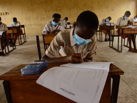 The final year students of Agidinbi Senior Grammar School,Ikeja, Lagos, wearing a facemask write on examination answer sheet during The West...