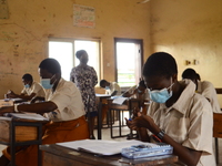 Final year students of Agidinbi Senior Grammar School,Ikeja, Lagos, wearing a facemask write on her hand during The West African Senior Seco...