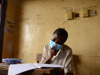 A final year students of Agidinbi Senior Grammar School,Ikeja, Lagos, wearing a facemask write on examination answer sheet during The West A...