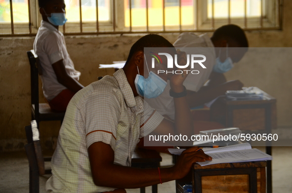 A final year students of Agidinbi Senior Grammar School,Ikeja, Lagos, wearing a facemask write on examination answer sheet during The West A...