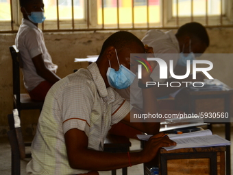 A final year students of Agidinbi Senior Grammar School,Ikeja, Lagos, wearing a facemask write on examination answer sheet during The West A...