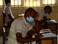 A final year students of Agidinbi Senior Grammar School,Ikeja, Lagos, wearing a facemask write on examination answer sheet during The West A...