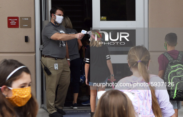 Principal Nathan Hay checks the temperatures of students as they return to school on the first day of in-person classes in Orange County at...