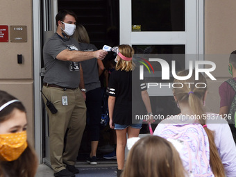 Principal Nathan Hay checks the temperatures of students as they return to school on the first day of in-person classes in Orange County at...