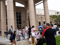 Parents walk their children to school on the first day of in-person classes in Orange County at Baldwin Park Elementary School on August 21,...