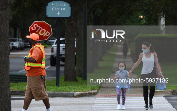 A mother walks her child to school on the first day of in-person classes in Orange County at Baldwin Park Elementary School on August 21, 20...