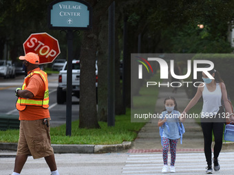 A mother walks her child to school on the first day of in-person classes in Orange County at Baldwin Park Elementary School on August 21, 20...