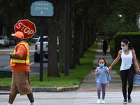 A mother walks her child to school on the first day of in-person classes in Orange County at Baldwin Park Elementary School on August 21, 20...