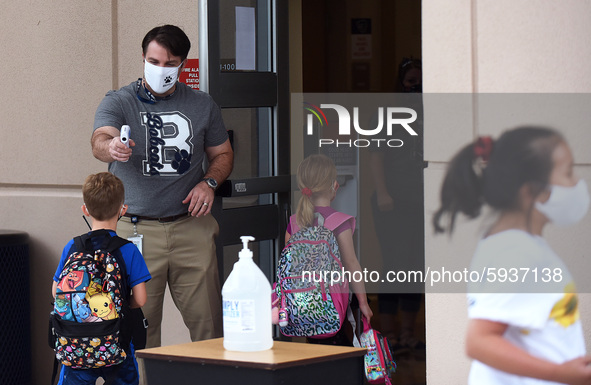 Principal Nathan Hay checks the temperatures of students as they return to school on the first day of in-person classes in Orange County at...