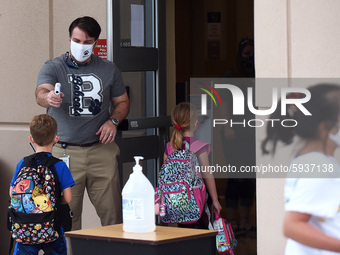 Principal Nathan Hay checks the temperatures of students as they return to school on the first day of in-person classes in Orange County at...