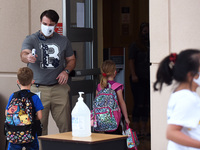 Principal Nathan Hay checks the temperatures of students as they return to school on the first day of in-person classes in Orange County at...