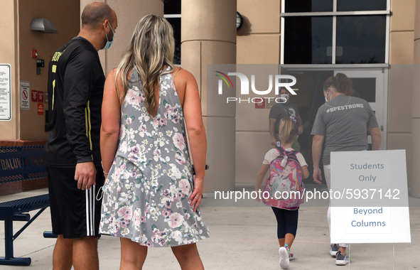 Parents watch as their child is escorted into the school building on the first day of in-person classes in Orange County at Baldwin Park Ele...