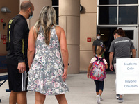 Parents watch as their child is escorted into the school building on the first day of in-person classes in Orange County at Baldwin Park Ele...