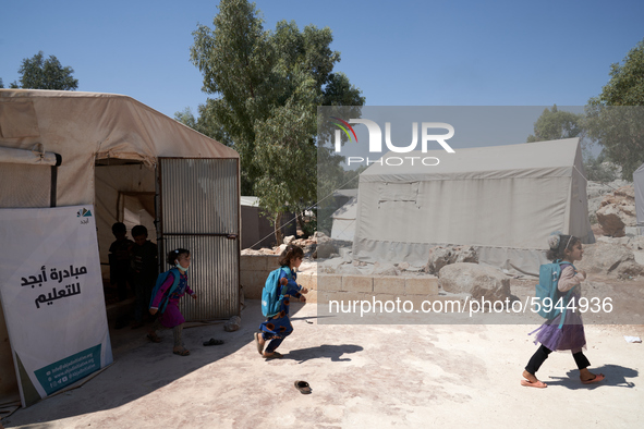 Syrian students leave the educational tent after taking a math lesson in a refugee camp near Syrian-Turkish borders in Idlib, Syria, on Augu...