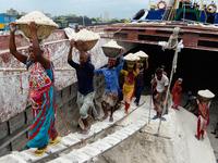 Day laborers unload sand from a cargo ship in Dhaka, Bangladesh on August 26, 2020. Dhaka is getting back to its normal life after months of...