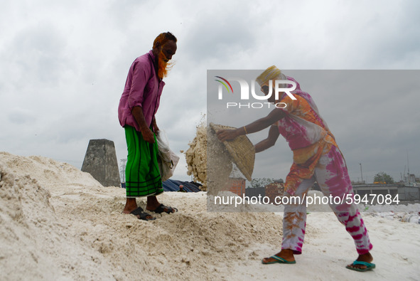 Day laborers unload sand from a cargo ship in Dhaka, Bangladesh on August 26, 2020. Dhaka is getting back to its normal life after months of...