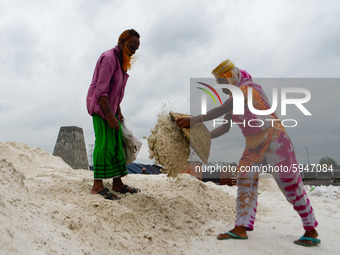 Day laborers unload sand from a cargo ship in Dhaka, Bangladesh on August 26, 2020. Dhaka is getting back to its normal life after months of...