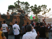 A Turkish military vehicle passes in front of a gathering of Syrians in an anti-Assad demonstration in Jabal al-Arbaeen in the town of Jeric...