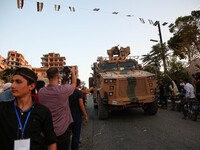 A Turkish military vehicle passes in front of a gathering of Syrians in an anti-Assad demonstration in Jabal al-Arbaeen in the town of Jeric...