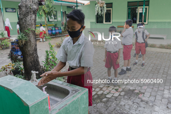 A student wash his hands before entering the classroom at Candirejo Elementary School, Semarang Regency, Central Java, Indonesia, on Septemb...