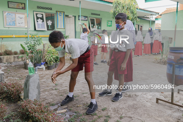 A student wash his hands before entering the classroom at Candirejo Elementary School, Semarang Regency, Central Java, Indonesia, on Septemb...