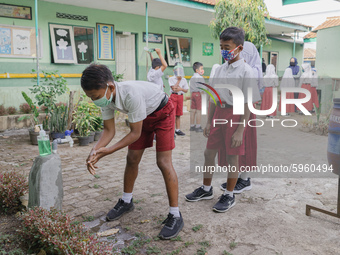 A student wash his hands before entering the classroom at Candirejo Elementary School, Semarang Regency, Central Java, Indonesia, on Septemb...