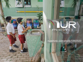 A student wash his hands before entering the classroom at Candirejo Elementary School, Semarang Regency, Central Java, Indonesia, on Septemb...