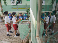 A student wash his hands before entering the classroom at Candirejo Elementary School, Semarang Regency, Central Java, Indonesia, on Septemb...