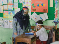 A teacher give explanation to a student at Candirejo Elementary School, Semarang Regency, Central Java, Indonesia, on September 1, 2020. Loc...