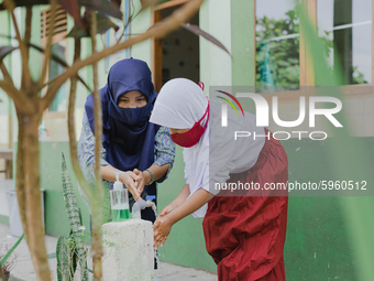 A teacher teach a student to wash her hands at Candirejo Elementary School, Semarang Regency, Central Java, Indonesia, on September 1, 2020....