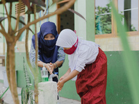 A teacher teach a student to wash her hands at Candirejo Elementary School, Semarang Regency, Central Java, Indonesia, on September 1, 2020....